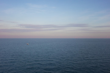 Blue ocean and sky with pastel clouds