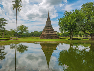 Fototapeta na wymiar Ruin of Pagoda in Wat mahathat Temple Area and reflection in the water At sukhothai historical park,Sukhothai city Thailand