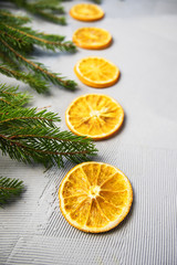 Fototapeta na wymiar Christmas Tree Pine Branches with oranges on a light background.
