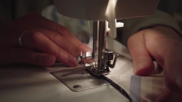 Woman sews fabric together with sewing machine