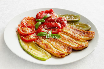 haloumi with roasted vegetables flavoured with olive oil, vinegar, and garlic sprinkled with black pepper and decorated with basil