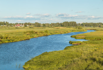 Fototapeta na wymiar River with green banks on a sunny summer day