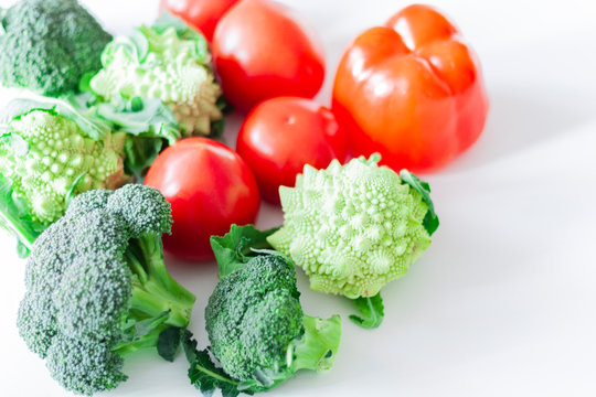 Ripe vegetables tomatoes romanescu broccoli on white wooden background with copy space for your text