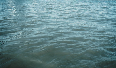 Water surface with ripples and sunlight reflections