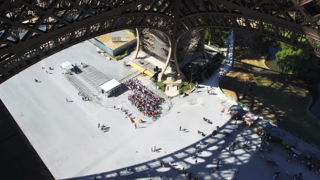 PARIS, FRANCE - CIRCA JUNE 2018: People waiting in line for entrance to the Eiffel Tower, view from the first floor. An anti-terror metal fence and bulletproof glass are being built around the tower.