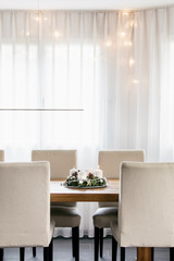 Advent Wreath with four candles. The first candle being lit on the first Sunday in December to celebrate the beginiing of Christmas holidays in Switzerland. Dining table decoration.