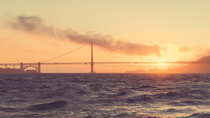 Golden Gate Bridge seen from ocean view in beautiful golden evening light. San Francisco, California, USA