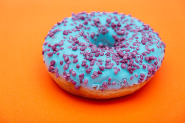 blue donut with sprinkles isolated on orange background