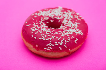 pink donut with sprinkles isolated on pink background