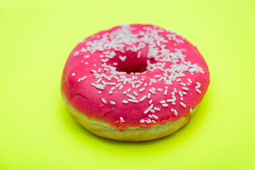 pink donut with sprinkles isolated on green background