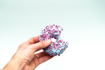blue donut with sprinkles in hand isolated on white background
