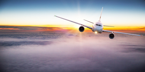Fototapeta na wymiar Commercial airplane flying above dramatic clouds.