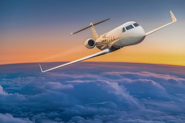 Fototapeta na wymiar Private jet plane flying above dramatic clouds.