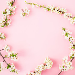 Fototapeta na wymiar Floral frame with white spring flowers isolated on pink background. Flat lay, top view. Spring time concept.