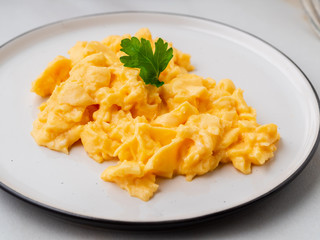 Scrambled eggs, Omelette. Breakfast with pan-fried eggs, cup of tea, tomatoes on white stone marble background. Side view, close up