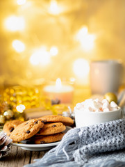 Christmas background with cocoa, marshmallow. Cozy evening, cup of drink, Christmas decorations, candles and lights garlands.