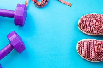 Fitness equipment dumbbells on color background. Flat lay.