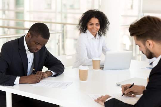 African american and caucasian businessmen signing contracts concept filling form making agreement or collaboration deal at group meeting, new diverse partners put signature on business documents