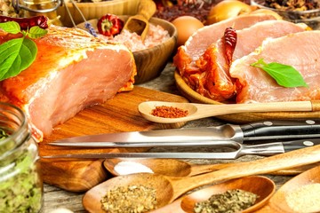 Pork chop on old wooden table. Raw meat and spices. Marinated pork meat on grill