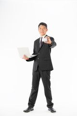 Business man in black suit holding laptop and blank card