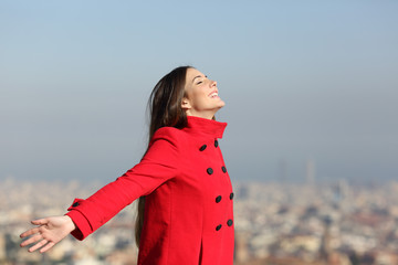 Happy woman breathing in the city
