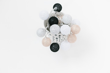 White, black, gold, silver christmas lights on white textured background.