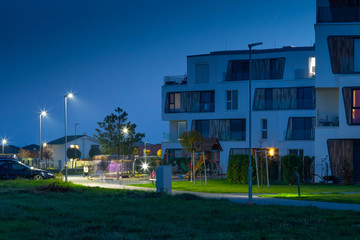 Fototapeta na wymiar night street with modern appartment house and LED street lights