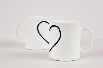 Drawn heart and two cups on white background. Valentine's day, love, couple, wedding concept