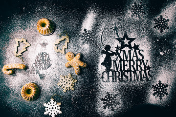 Christmas mini bundt cake and decoration on a black board with icing sugar and stenciled christmas...