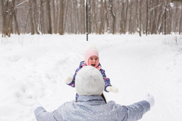 Family, children and nature concept - Mother with daughter have fun in the winter park