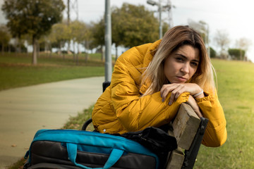 Pretty blonde girl with laptop backpack in a park