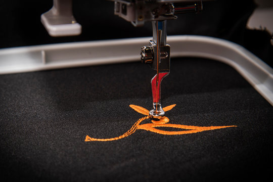 Exquisite Embroidery: Macro Shot of Orange Embroidered Design on Black Fabric