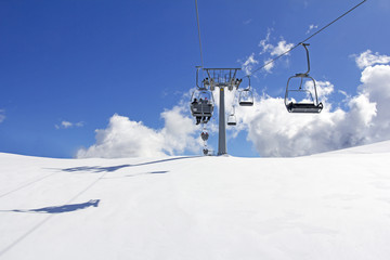 Fototapeta na wymiar Mountain slopes with Ski lift on a winter sunny day