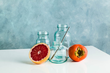 empty glass recycled bottles for breakfast, fresh juice and other kitchen needs. glassware on white table and blue background