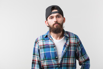Fototapeta premium Beauty, fashion and people concept - Portrait of a young bearded hipster stylish guy over white background.