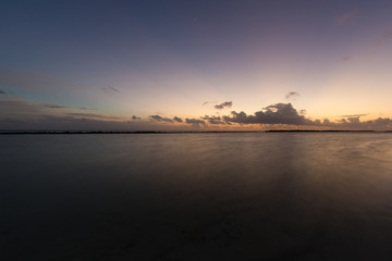 Fototapeta na wymiar Minimalistischer Sonnenuntergang auf den Malediven mit glattem Meer