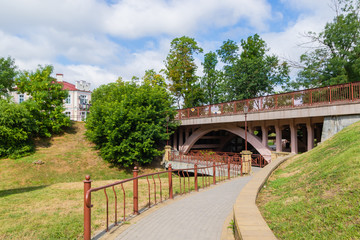 Fototapeta na wymiar Park walkway leaving under the bridge. Grodno, Belarus