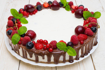Delicious tart with fresh strawberries, raspberries and cherry on the table