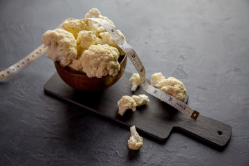 Bol con coliflor y una cinta métrica 