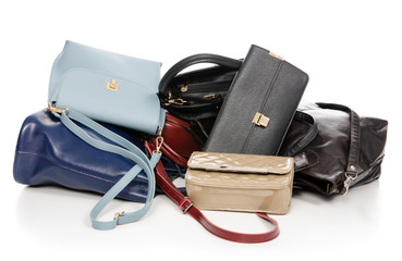Woman's female bags pile many different on white background isolation