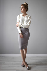 Full length vertical image of glamourous beautiful young female employee or teacher wearing high...