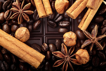 Christmas decor with dark chocolate coffee beans cinnamon nuts and star anise and empty place for text