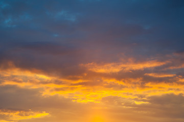 Naklejka na ściany i meble Dramatic view on a orange clouds in sunset sky
