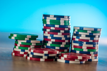 Obraz premium Casino chips on wooden table with blue background