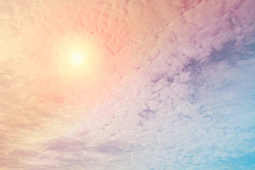 Abstract view on a fantastic soft clouds with pastel color and sun in the sky as background