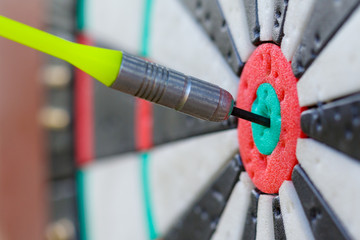 Fototapeta na wymiar View on a fragment of dartboard with dart in a bullseye (shallow depth of field, concept)