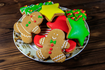 Plate with tasty festive Christmas gingerbread cookies on wooden table