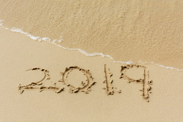 Fototapeta na wymiar New Year concept 2019 number written on sand beach