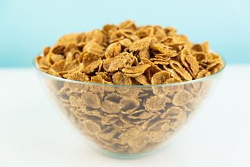 Healthy breakfast food macro shot. Close-up image of whole grain cereals in glass bowl.