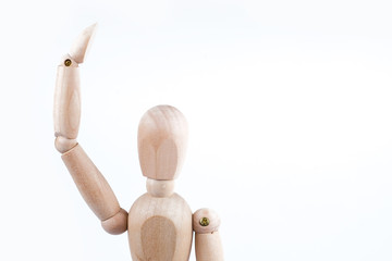 The concept of joyful greeting. Wooden mannequin raised his hand on a white background. Copy space.